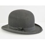 A vintage bowler hat with leather and si