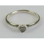 A silver Pandora ring having heart set w