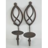 A pair of wrought iron wall mounted cand