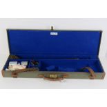 A 20th century canvas covered 12 gauge shotgun case, leather handle, twin straps, brass lock,