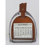 A perpetual desk calendar in the form of a stirrup measuring 18.5cm high.