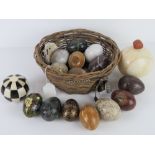 A basket containing a quantity of marble and papier mache eggs, an onyx sphere, etc.