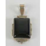 A 925 silver and square shaped onyx pendant having hinged bale over, 4.2cm in length.