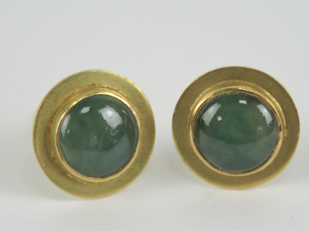 A pair of yellow metal stud earrings having green and white jade cabachon to centre,