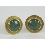 A pair of yellow metal stud earrings having green and white jade cabachon to centre,