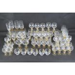 A large quantity of matching amber stemmed glass ware including champagne flutes, champagne saucers,