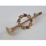 A 9ct gold stock pin brooch in the form of a hunting horn having ruby and pearl wreath surrounding,