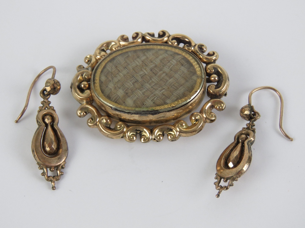 A Victorian pinchbeck spinning fob brooch having woven blonde hair to one side,