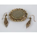 A Victorian pinchbeck spinning fob brooch having woven blonde hair to one side,