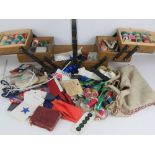 A c1930s cantilever sewing box containing a large quantity of sewing ephemera, needles, threads,