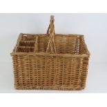A wicker picnic basket having loop handle and dividers to hold three bottles, 48 x 38cm.