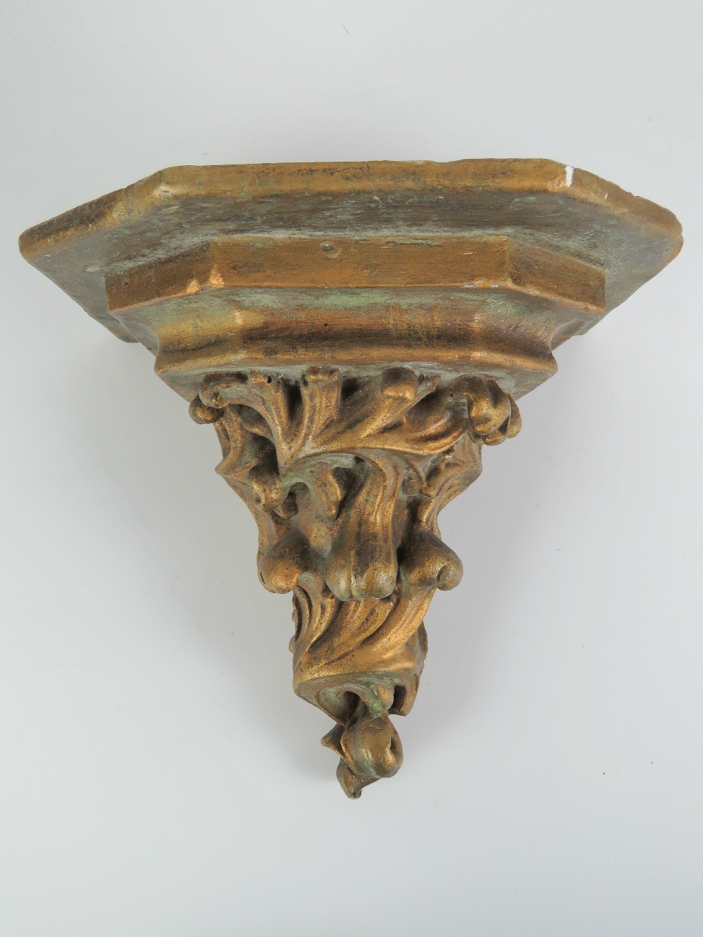 A gold painted cast resin decorative wall bracket, 21 x 20cm.