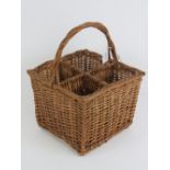 A four sectional wicker picnic wine basket with integral woven hoop handle, 36cm high.