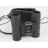 A pair of folding 8 x 21 Hawke binoculars with leatherette carry pouch.