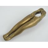 A 'risque' hinged bottle opener in the form of a pair of shapely female legs, 12cm in length.