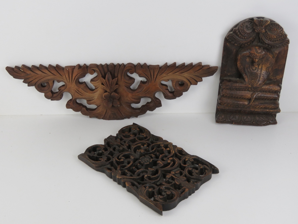 A carved Indo Asian wooden wall plaque having coiled serpent upon, 30 x 17cm high.