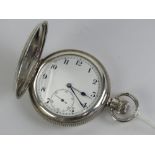 A hallmarked silver full hunter top wind pocket watch having white enamel dial with black Arabic