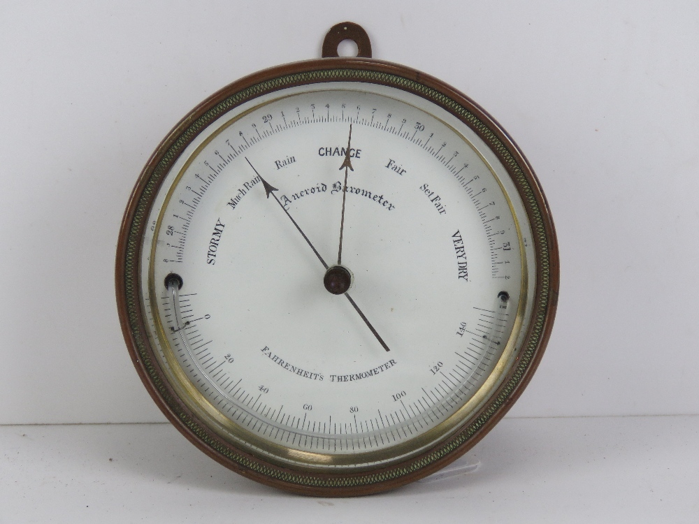 A copper cased Farenheight thermometer and aneroid barometer, wall hanging, 12cm dia.