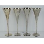 Links of London; a set of four silver plated champagne flutes, each standing 25cm high.