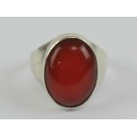 A HM silver carnelian signet ring having large central oval cabachon 17 x 12mm, worn hallmark,