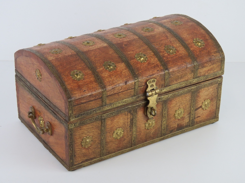 A wooden domed top lidded casket with gilt brass ornamentation throughout,