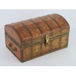 A wooden domed top lidded casket with gilt brass ornamentation throughout,