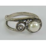 An Arts and Crafts style hand planished silver ring set with pearl and white stone, size S.