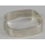 A 925 silver bangle of square form, 5.8 x 5.2cm internal dia, 15mm wide.