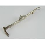 A silver stock pin or brooch in the form of a riding crop with horse head in bridle over,