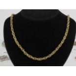 A 9ct gold chain necklace having polished double links surrounding a row of planished links,