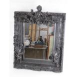 A highly decorative bronzed composite square shaped wall mirror having floral and foliate swags