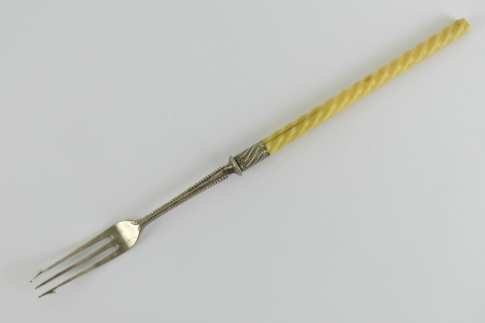 A pickle fork having twist carved ivory handle and white metal fittings, 23cm in length.