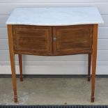 An Edwardian marble top bow fronted double door wash stand, raised over square tapering legs,