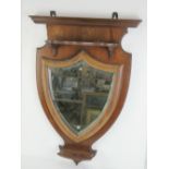 A wall hanging hall mirror having bevel edged shield shaped mirror with shelf over and under 80 x