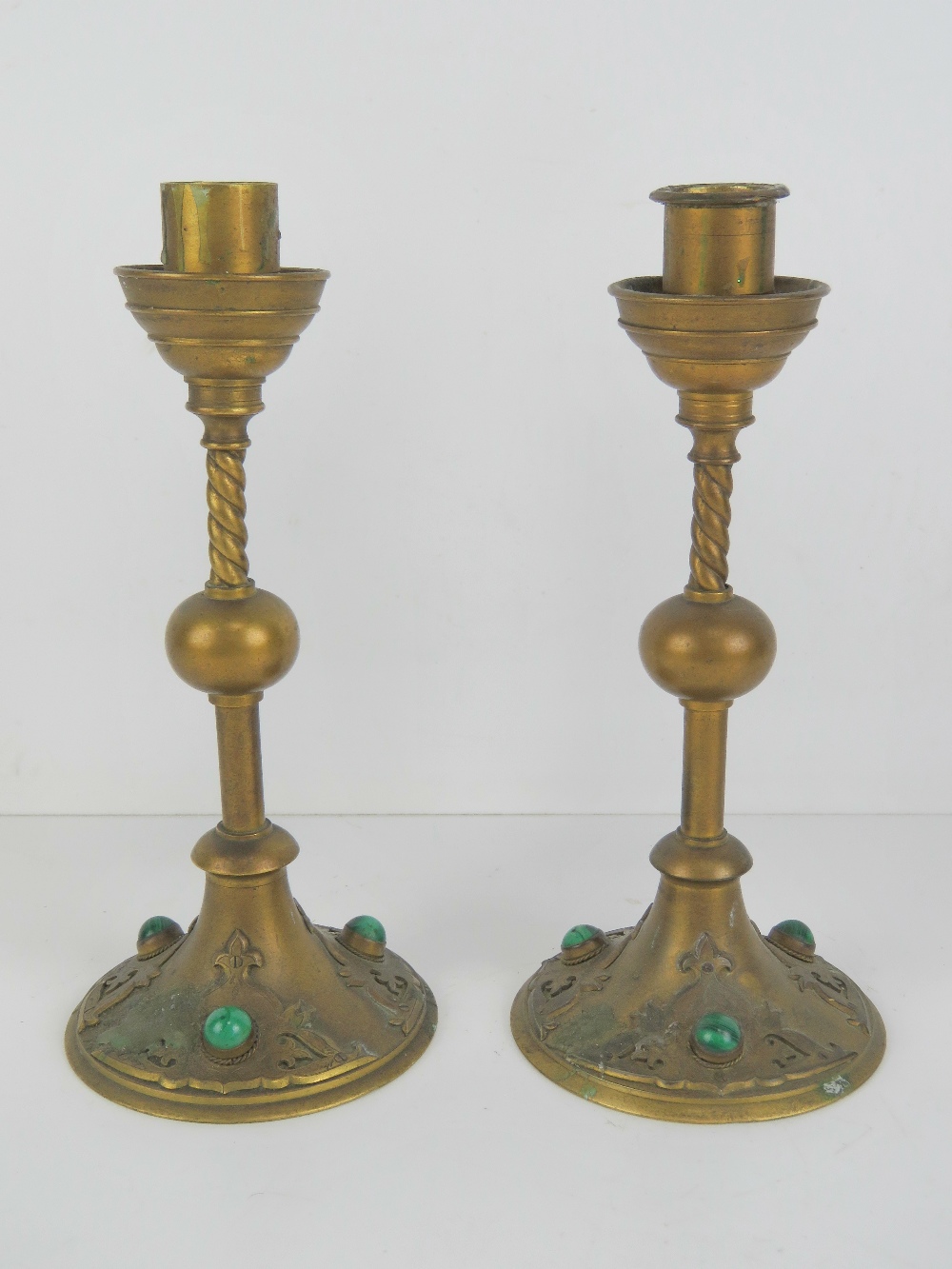 A pair of Gothic Revival brass candlesticks inset with malachite cabachons, each 22cm high.
