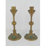 A pair of Gothic Revival brass candlesticks inset with malachite cabachons, each 22cm high.