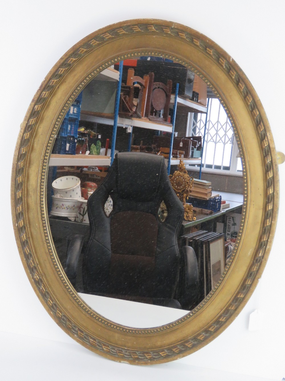 An oval gilt framed over mantle mirror,