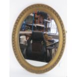 An oval gilt framed over mantle mirror,
