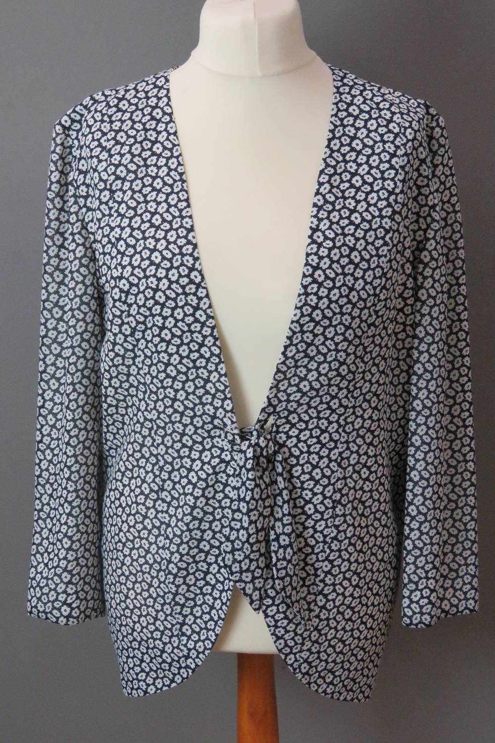 Frank Usher; a light floral jacket having tie waist in navy and white, UK size 12.