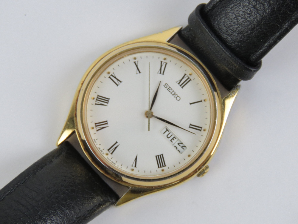 A Seiko quartz wristwatch having white dial with date and date apertures, on black leather strap.