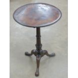 A circular occasional table raised over three outswept feet, 46cm diameter, 67cm high.