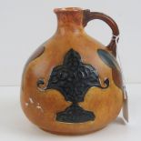 A Chameleon ware hand painted bottle vase with handle decorated in relief, standing 16cm high.