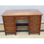 An Edwardian kneehole desk, central drawer flanked by twin banks of four drawers,