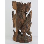 A carved rosewood Indo-Asian figurine of two figures in ceremonial dress, 31.5cm high.