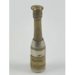 A champagne themed cigar piercer 'Veuve Cliquot', brass and silver plate, standing 7cm high.