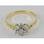 An 18ct gold and diamond cluster ring having raised gallery of claw set round cut diamonds in daisy