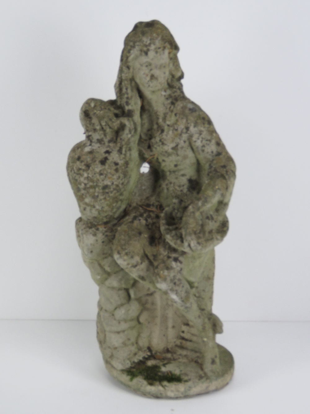 A precast stone garden ornament figurine 47cm high. Seated female with urn.