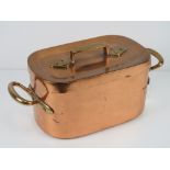 A copper pan with lid having brass end handles and brass handle to lid, 43cm total width.