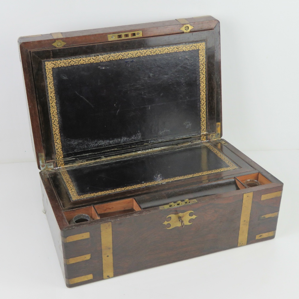 A fine mahogany writing slope having brass banding, hinges and escutcheon plate,