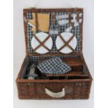 A wicker picnic hamper in unused condition complete with thermos, champagne glasses, cruet, cutlery,